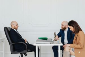 A couple consulting with an attorney, discussing divorce indoors.